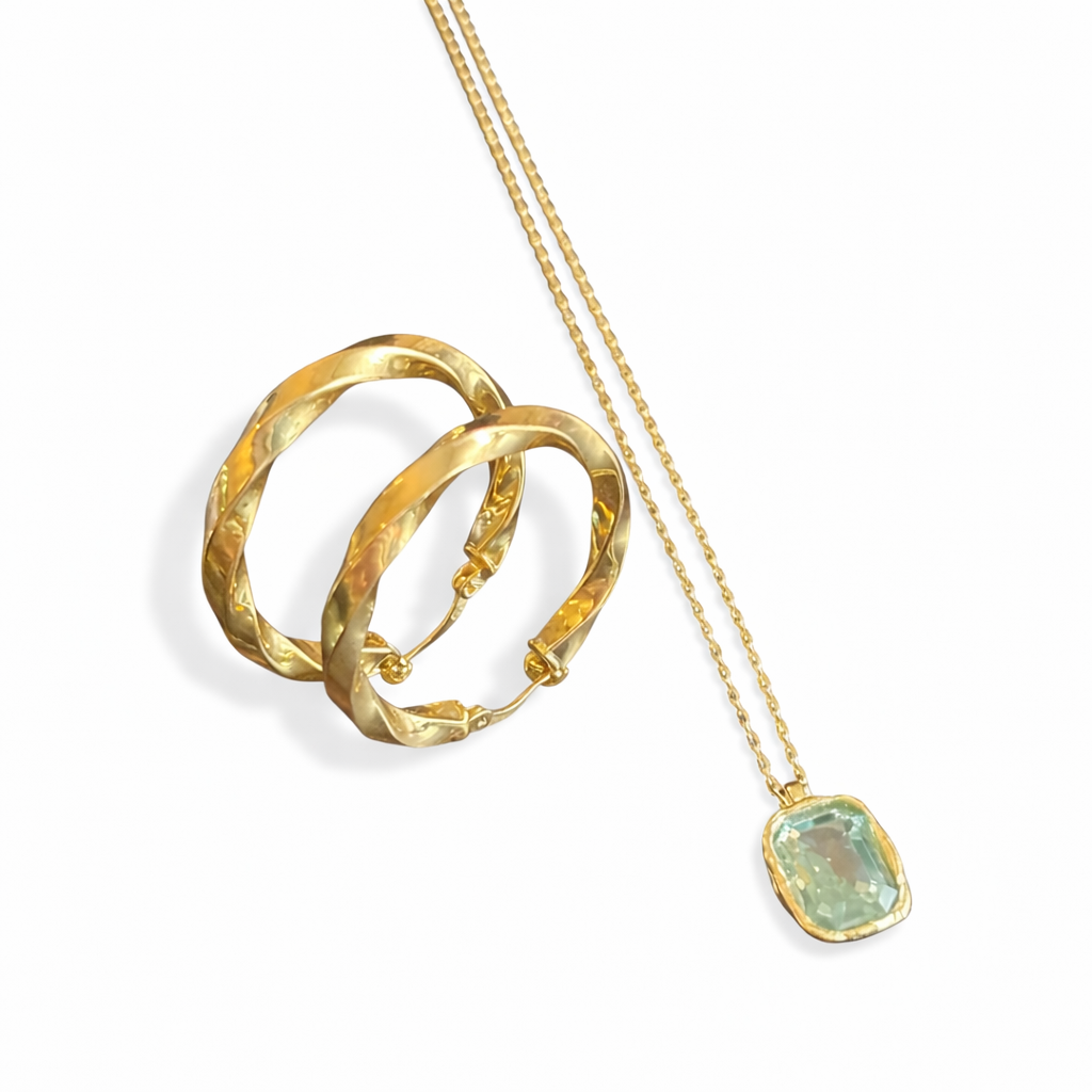 Gold hoop earrings and necklace with a green gemstone on a white background
